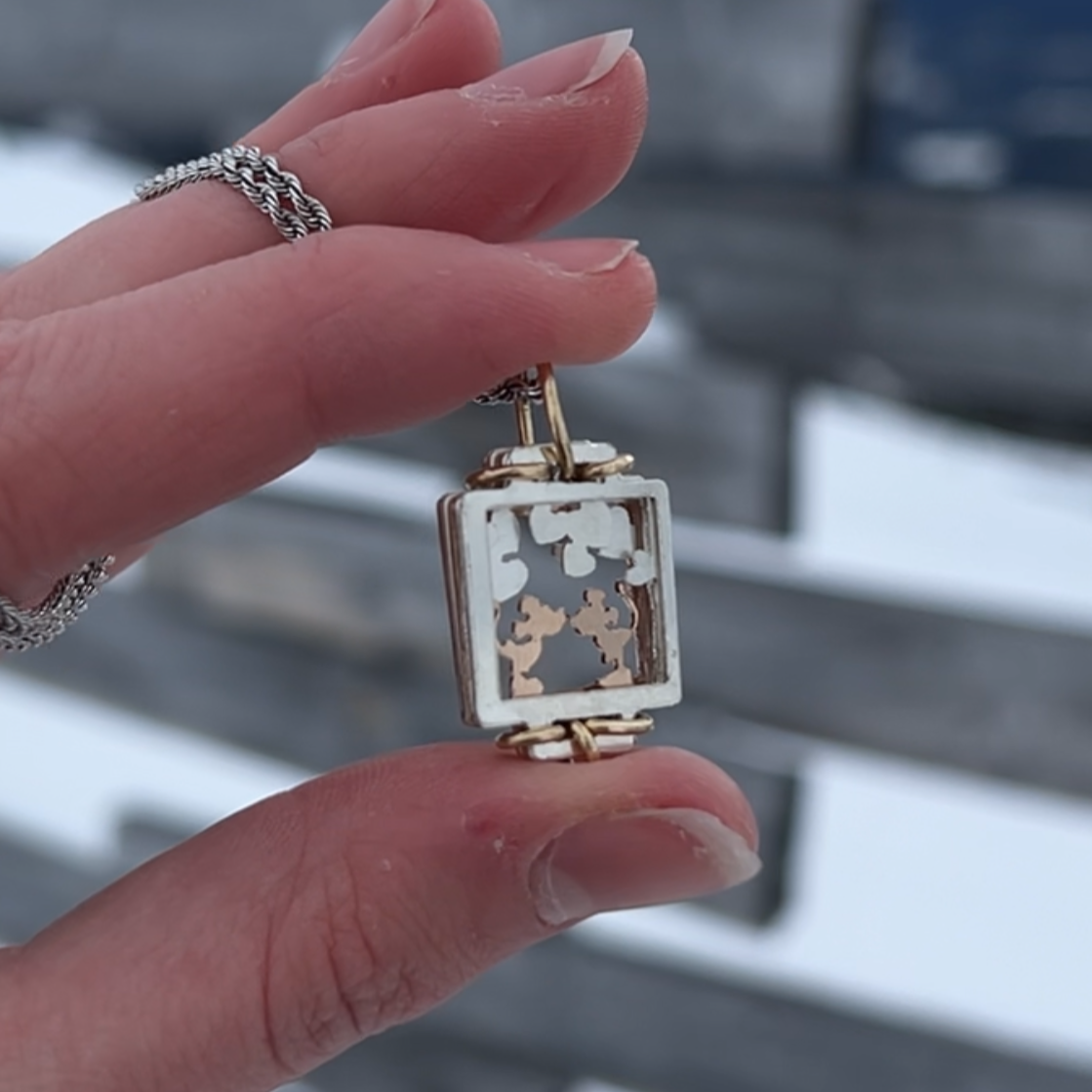 Mickey and Minnie Leaning in to kiss pendant, with hearts above. Silver front fram.